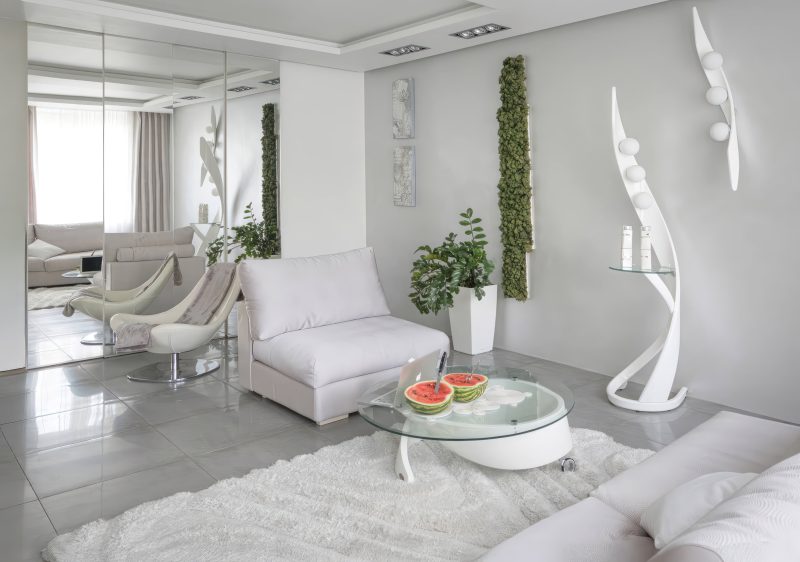 Интерьерная съемка белой гостиной от фотографа Кирилл Толль. Метро Беговая. Философия минимализма в объективе. Московский мастер виртуозно передает суть современного пространства, где царит культ света, воздуха и свободы. Кадр выстроен вокруг идеи функционального аскетизма, где каждый предмет обретает высший смысл. Светло-серые стены, бежевые текстильные поверхности, строгая геометрия мебели — все сливается в единую симфонию покоя. Фотография становится манифестом нового урбанистического быта.