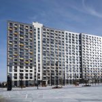 Фрагмент жилого дома в ЖК Новый Зеленоград с благоустроенным тротуаром и припаркованными автомобилями.