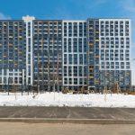 Фасад корпуса 3 ЖК Новый Зеленоград (Химки, д. Рузино). Отделка фиброцементом, серо-белая гамма, жёлтые акценты на балконах.