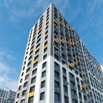 Нижний ракурс ЖК Новый Зеленоград. Устремленность вверх, мозаика фасада из серых и охристо-желтых панелей.