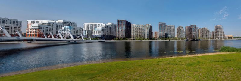 Панорама Нагатинского затона вечером: маяк, мост, ЖК Ривер Парк, силуэты башен и отражения в воде