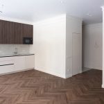 Съемка встроенных шкафов в жилой комнате. Фасады с текстурой дерева, ручки.