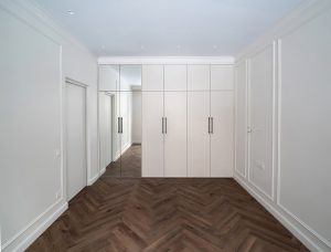 Съемка интерьера маленькой комнаты. Функциональное пространство со шкафом и столом у окна.