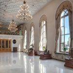 Роскошный вестибюль отеля с массивной лестницей и хрустальной люстрой