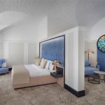 Фотосъемка отелей под ключ: уютный уголок номера с кроватью и прикроватными тумбами. Услуги фотографа Кирилла Толля включают полный цикл - от подготовки помещения до финальной обработки снимков.