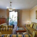 Evening ambiance in a hotel suite living room, professionally captured by Kirill Toll. The warm lighting and cozy arrangement of sofas create a welcoming mood, showcasing the photographer's skill in setting the scene for hospitality.