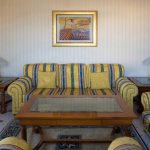 A comprehensive view of a hotel living area, skillfully framed by photographer Kirill Toll. This professional shot highlights the functionality and social space of the suite, essential for marketing to families and business travelers alike.