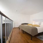 How to capture the tranquility of a sleeping area in a two-storeyed room? This professional photo by Kirill Toll uses lighting and composition to create an inviting and restful atmosphere. Professional interior photography services.