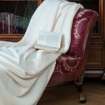 Интерьерная съёмка антикварного кресла с резьбой и книгой.