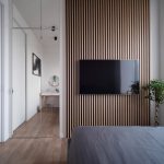 Современная спальня с деревянной реечной панелью и зеркальным шкафом в ЖК Ривер Парк