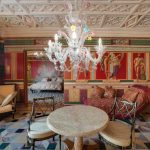 Интерьер центральной залы в ЖК Новопесковский (Арбат) с мраморным столиком для игр, античными фресками на красном фоне и видом на мастер-спальню — Кирилл Толль