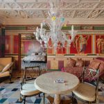 Интерьер залы в ЖК Новопесковский на Арбате: мраморный стол, муранская люстра с цветами, вид на спальню через анфиладу и античная роспись стен — работа Кирилла Толль