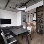 Дизайн гостиной с бетонным потолком и кольцевой люстрой в ЖК Ривер Парк