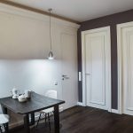 Вид на столовую группу и межкомнатные двери у метро Трубная — тёмный стол, хромированные подвесы и белые двери на сиреневой стене. Съёмка: Кирилл Толль