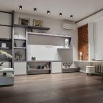 Широкий план гостиной с большим стеллажом, кирпичной стеной и сиреневым акцентом у метро Трубная. Фото: Кирилл Толль