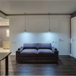 Общий вид зоны отдыха и дверей у метро Трубная — диван с зигзагообразным узором, подвесные светильники и потайная дверь. Фото: Кирилл Толль