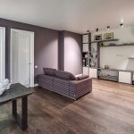 Широкоугольный план гостиной и столовой у метро Трубная — диван, обеденный стол, белые двери и стеллаж. Съёмка: Кирилл Толль