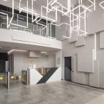 Футуристичное лобби ЖК Loftec между Бауманской и Красносельской с зоной ресепшн, геометрическими панелями с подсветкой и неоновой световой инсталляцией на потолке — фото Кирилла Толль