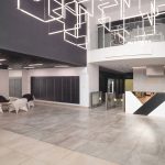 Просторное лобби ЖК Loftec с полигональными белыми креслами в лаунж-зоне, стеной с почтовыми ящиками и геометрической световой инсталляцией на потолке — съёмка Кирилла Толль