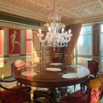 Роскошная столовая в ЖК Новопесковский на Арбате: панорамное окно с видом на Москву, антикварная мебель, муранская люстра и расписной кессонный потолок в лучах заката — съёмка Кирилла Толль