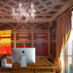 Кабинет в ЖК Новопесковский на Арбате в лучах закатного солнца: вид на московские высотки, архитектурные фрески, стол с инкрустацией и люстра из муранского стекла — работа Кирилла Толль