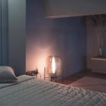 Спальня на антресольном этаже в ЖК Loftec с приглушённым освещением, дизайнерским напольным светильником и круглым зеркалом на стене — фото Кирилла Толль