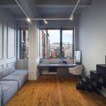 Двухуровневый лофт в ЖК Loftec между Бауманской и Красносельской с серым модульным диваном, парящей чёрной лестницей и рабочей зоной у панорамного окна — фото Кирилла Толль