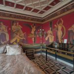 Деталь интерьера спальни в ЖК Новопесковский: антикварное чёрное бюро с инкрустацией, античный торшер и стены с помпейской художественной росписью — работа Кирилла Толль