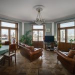 Интерьер эркерной гостиной на Большой Полянке с панорамным видом на Кремль и Храм Христа Спасителя. Кожаные диваны, обеденная зона.