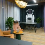 Представительский кабинет в БЦ Авилон Плаза с настенной монохромной графикой космонавта кожаными креслами кофейным столиком с флорариумами и серыми портьерами