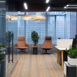 Офисное пространство open space со столами сотрудников белыми экранами перегородками тонированным стеклом кабинета лаунж зоной и полосатым ковролином