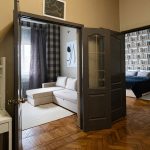 Анфилада комнат: вид из прихожей на гостиную с диваном и спальню с книжной стеной в квартире у Патриарших прудов