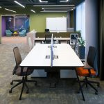 Офисный зал open space с белыми столами, эргономичными креслами, оливковой стеной и проходом в лаунж-зону, фотограф Кирилл Толль