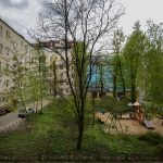 Вид из окна квартиры на тихий двор с детской площадкой и зеленью в районе Патриарших прудов
