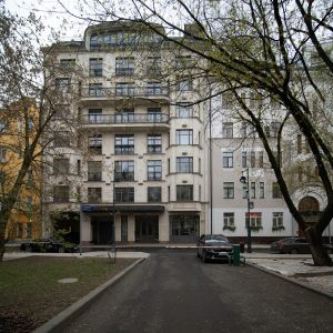 Архитектурный вид на фасад исторического доходного дома по адресу Трехпрудный пер., 11/13 стр. 2 (угол Благовещенского переулка). Район Патриарших прудов, метро Маяковская и Пушкинская. Вид на угловую эркерную башню с куполом и лепным декором.