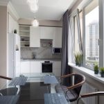 Современная кухня в ЖК Мосфильмовский с панорамным окном. Белые глянцевые фасады, стеклянный обеденный стол, вид на высотки Раменок. Мосфильмовская 88к4с2.