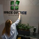 Визуальный манифест слогана Details matter. Менеджер Ольга зафиксирована со спины в момент финальной протирки букв вывески SPACE OFFICE. На руках девушки надеты белые трикотажные перчатки для защиты глянцевого пластика логотипа от отпечатков пальцев. Фиксация момента перфекционизма.