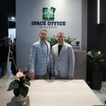 Парадный поясной B2B-портрет руководства. Соучредители ООО СПЕЙСОФИС Рустем Алиевич Мамин в сине-сером клетчатом пиджаке и Денис Николаевич Медведев в светлом пиджаке и очках позируют строго по центру под светящимся объемным логотипом компании. Компенсация контраста трекового света.