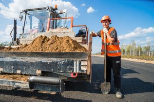 Рабочий асфальтоукладчика за работой, портрет в процессе