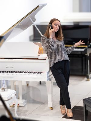 портрет девушки, консультирующей покупателя по телефону. Самый старший продавец скрипок