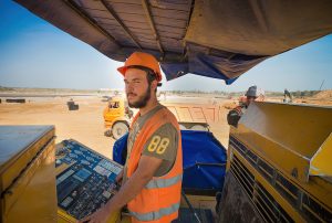Уверенный оператор асфальтоукладчика, портрет профессионала
