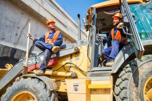 Братья-строители сидят на технике, беззаботные и веселые