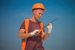 Студент с бензорезом, портрет молодого рабочего в спецовке